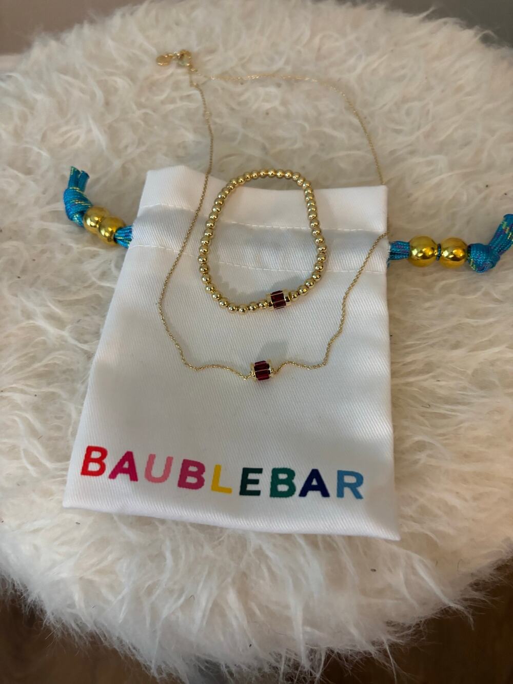 BaubleBar Tatum Ruby Bracelet paired with a matching necklace